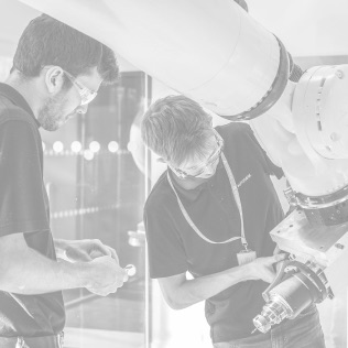 Black and white photo of two men inspecting a robotic arm