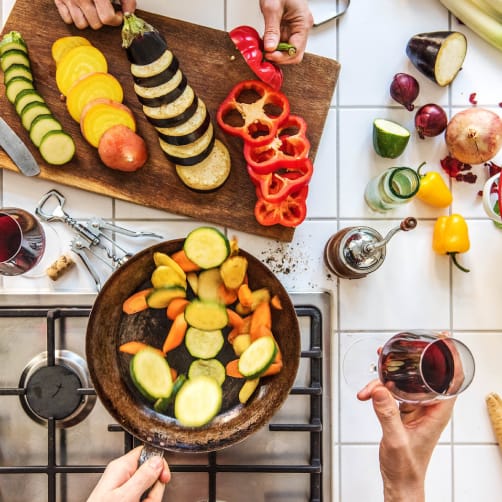Visão aérea de duas pessoas preparando uma refeição na cozinha