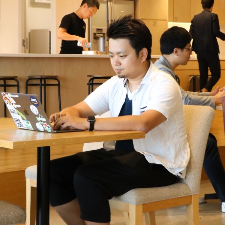 カフェでノートパソコンで作業する男性