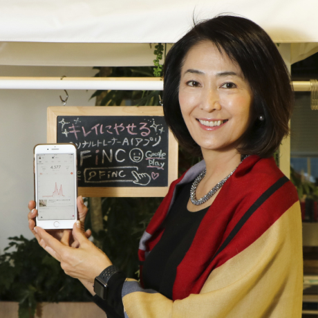 FiNC アプリをスマートフォンで紹介する人