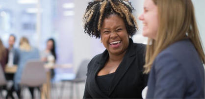 'Two RBC employees share a laugh in a conference room.'