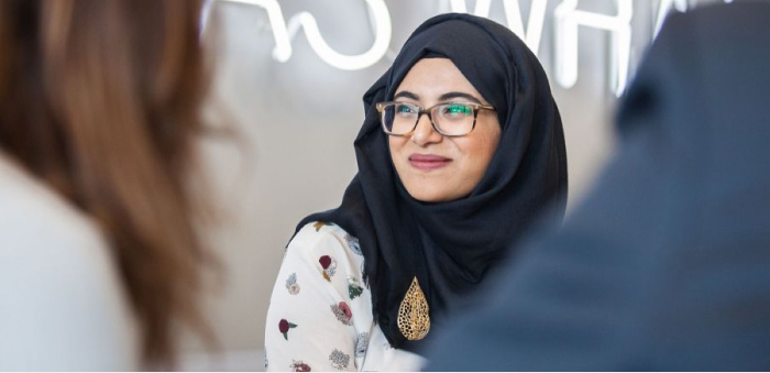 'An RBC customer smiles during an exchange with bank employees.'