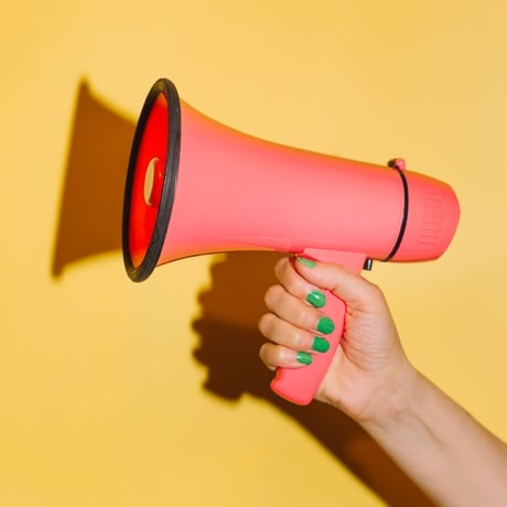 Hand holding a pink megaphone