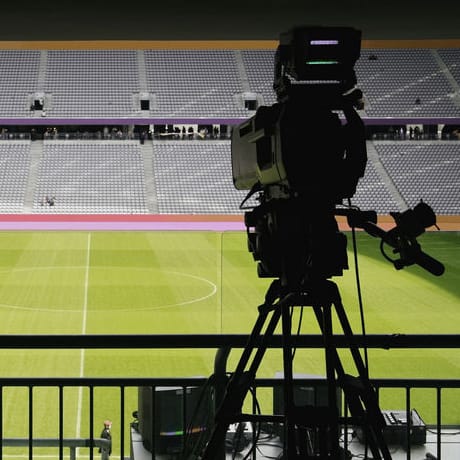 Television camera pointed towards the pitch in a soccer stadium