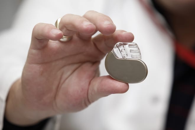 A doctor wolds a small pacemaker in her hand.