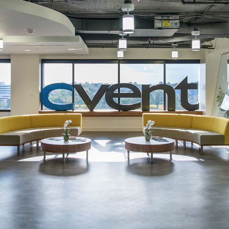 Image shows the Cvent offices with a large logo against a window with blue sky behind.