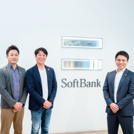 Image of Kunihiro Fujinaga, Keiichi Makizono and Kazushi Iizuka standing in front of Softbank's logo