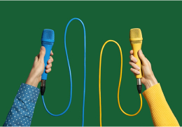 Two hands holding different colored microphones representing leaders discussing the new way of work